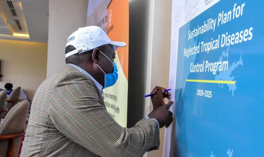 A representative from Uganda’s Ministry of Education signs Uganda’s sustainability plan for NTDs at the launch event on February 4, 2021