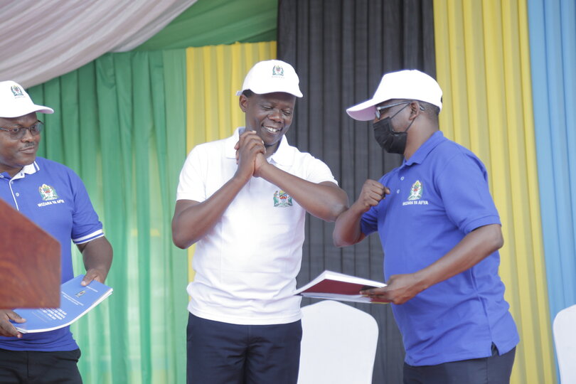 Dr. Godwin Mollel, Deputy Minister of Health,  distributes copies of the new Master plan and Sustainability Plan for NTDs in Tanzania