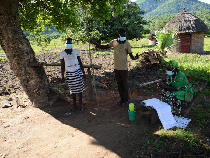 Trained volunteers distribute medicines to prevent onchocerciasis to a woman in Uganda’s Moyo district.  Photo credit: The Carter Center/Aggrey Mugisha