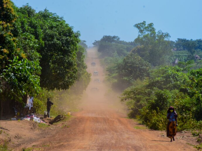 Cars travel down a dusty road near Moroto Uganda