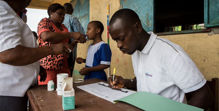 A health worker enters treatment data during a school-based NTD campaign