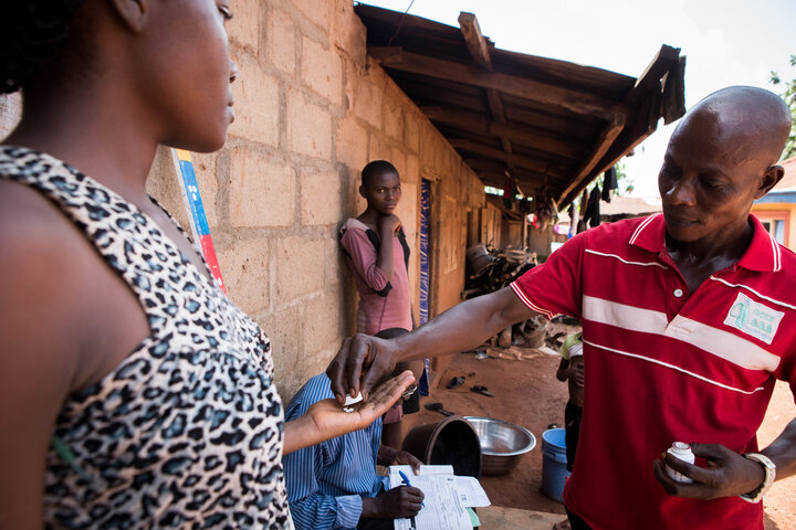 Community drug distributors provide treatment to a woman during a mass treatment campaign in Nigeria. 