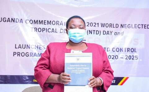 Hon. Minister of State for Health, Hon. Rhobinah Nabbanja shows Uganda’s newly launched sustainability plan for NTDs at the launch on February 4, 2020. 
