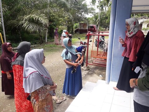 Wita Larasati explains LF medicines to breastfeeding woman during an NTD campaign in Indonesia. 