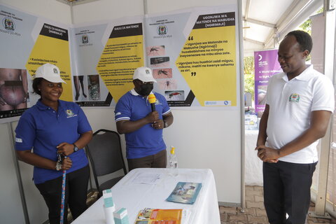 Deputy Minister of Health, Dr. Godwin Mollel visits a booth to learn about efforts to eliminate lymphatic filariasis in Tanzania during the launch event in Nyerere Square Grounds. 