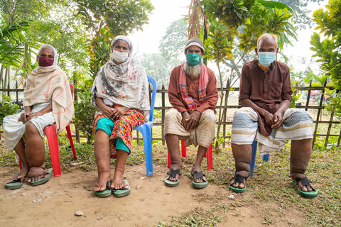 Patients, including Menu Bala (far left) and Mohim Uddin (far right), wait outside of a health clinic to receive counseling and care for leg swelling caused by a neglected tropical disease. Photo credit: RTI International/ Abir Abdullah