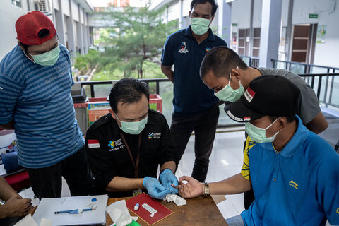 Representatives from the Indonesian Ministry of Health train health workers and lab technicians on blood sample collection ahead of a night blood survey. Photo Credit: Oscar Siagian / RTI International