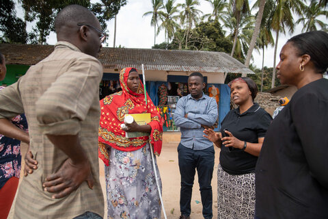 Dr. Faraja Lyamuya, LF Focal Person for the Ministry of Health in Tanzania, consulting with community health workers during a LF treatment campaign in Kilwa District, Tanzania. Photo credit: RTI International/Roshni Lodhia