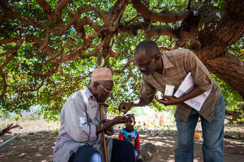 A community drug distributor gives medicine to a family at their home in Tanzania to help them prevent LF infection. Photo Credit: RTI International/Roshni Lodhia