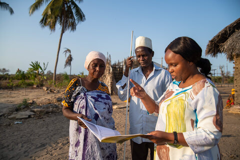 Dr. Faraja Lyamuya, LF Focal Person for the Ministry of Health in Tanzania, consulting with community health workers during a LF treatment campaign in Kilwa District, Tanzania. Photo credit: RTI International/Roshni Lodhia